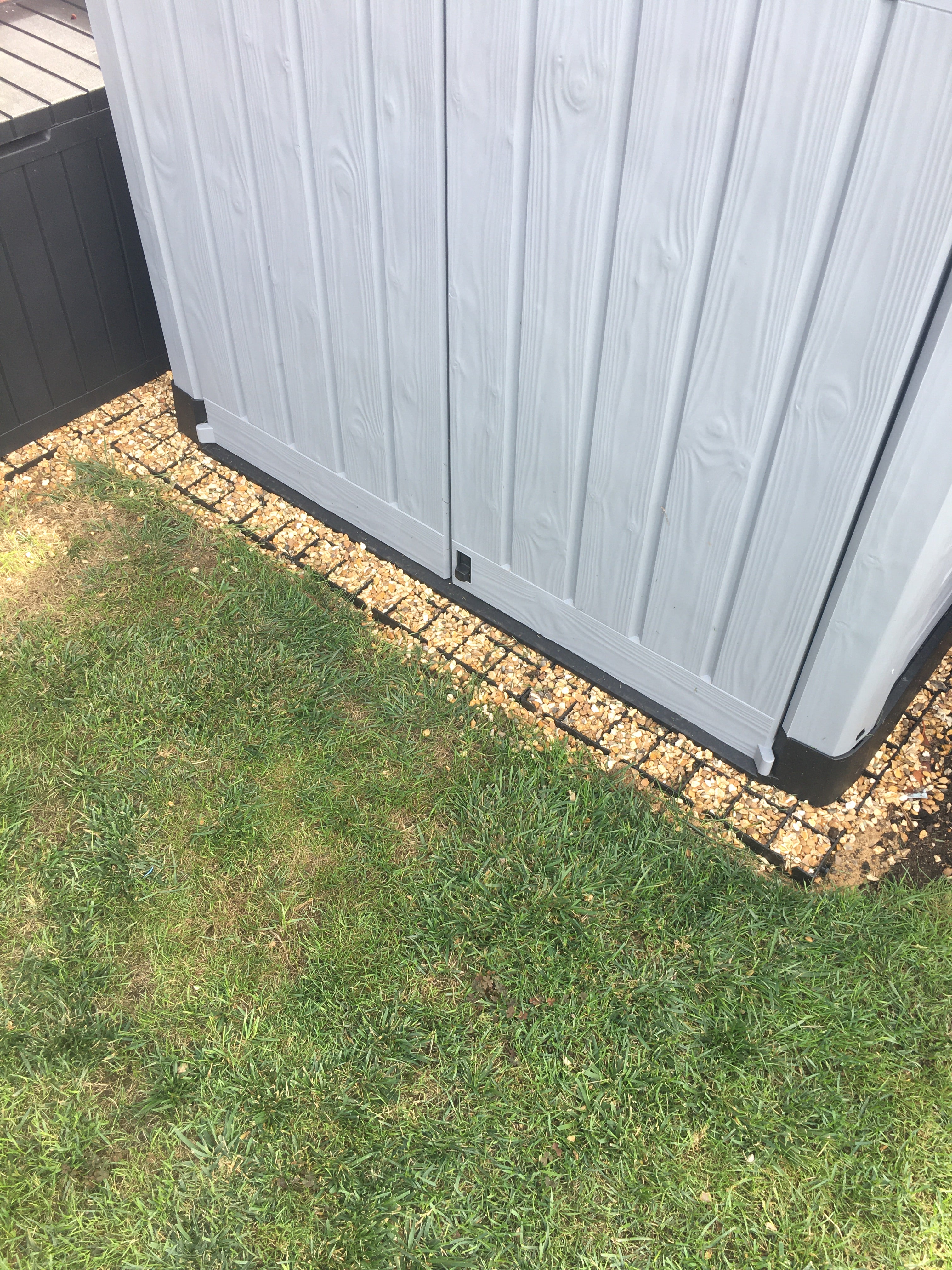 Plastic shed sitting on top of recycled plastic shed base grids